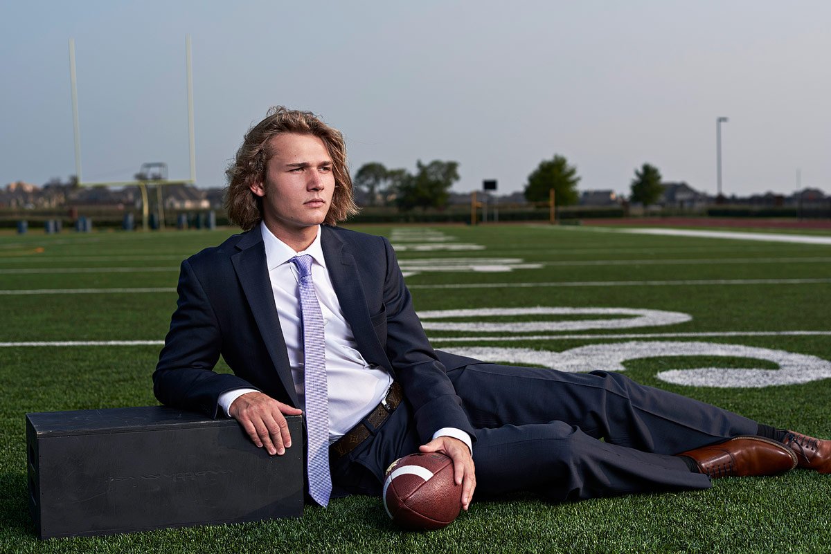dallas senior portrait photographer from mckinney texas takes photos of prosper football player in a suit