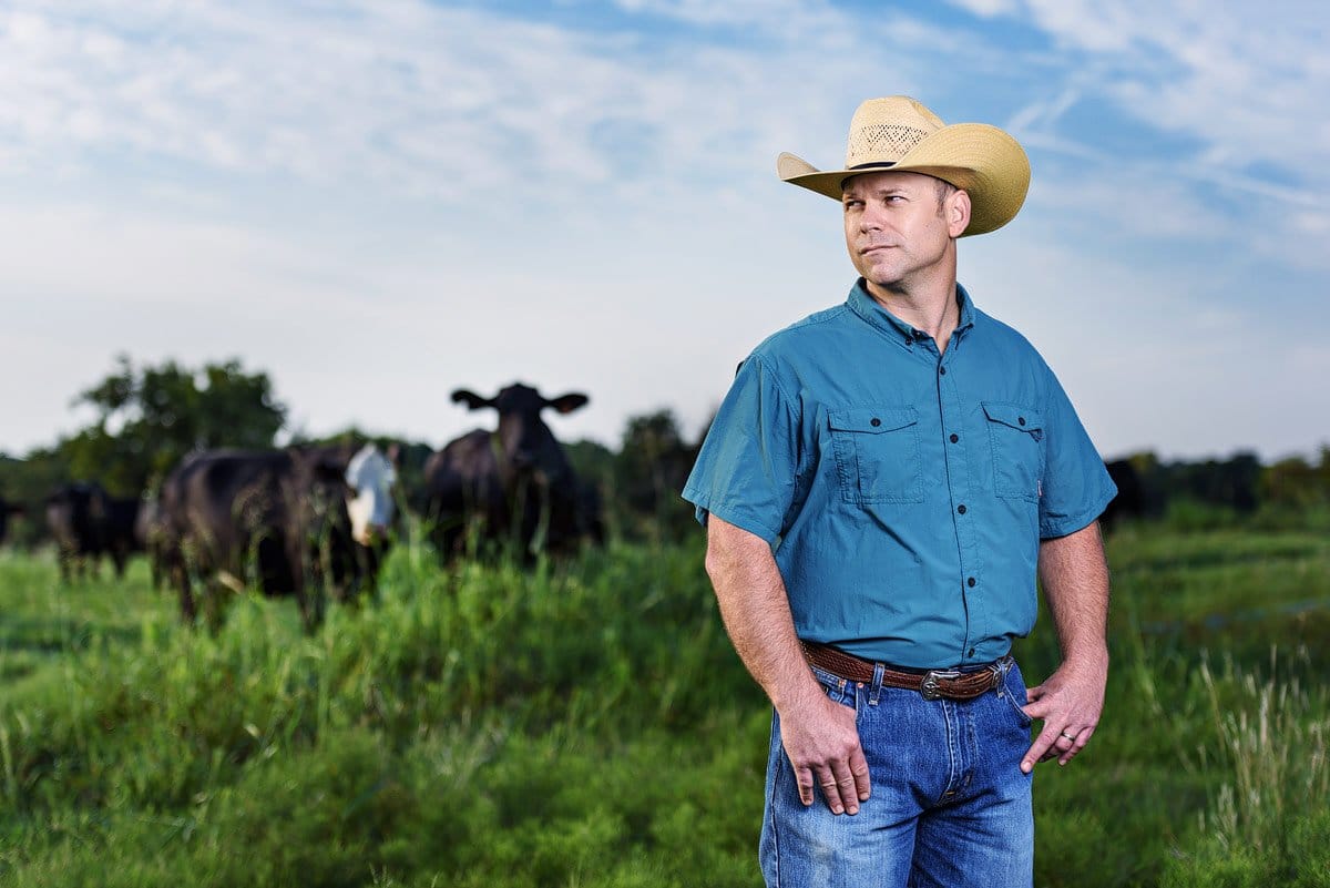 mckinney headshot with cows in background on farm local yocal owner