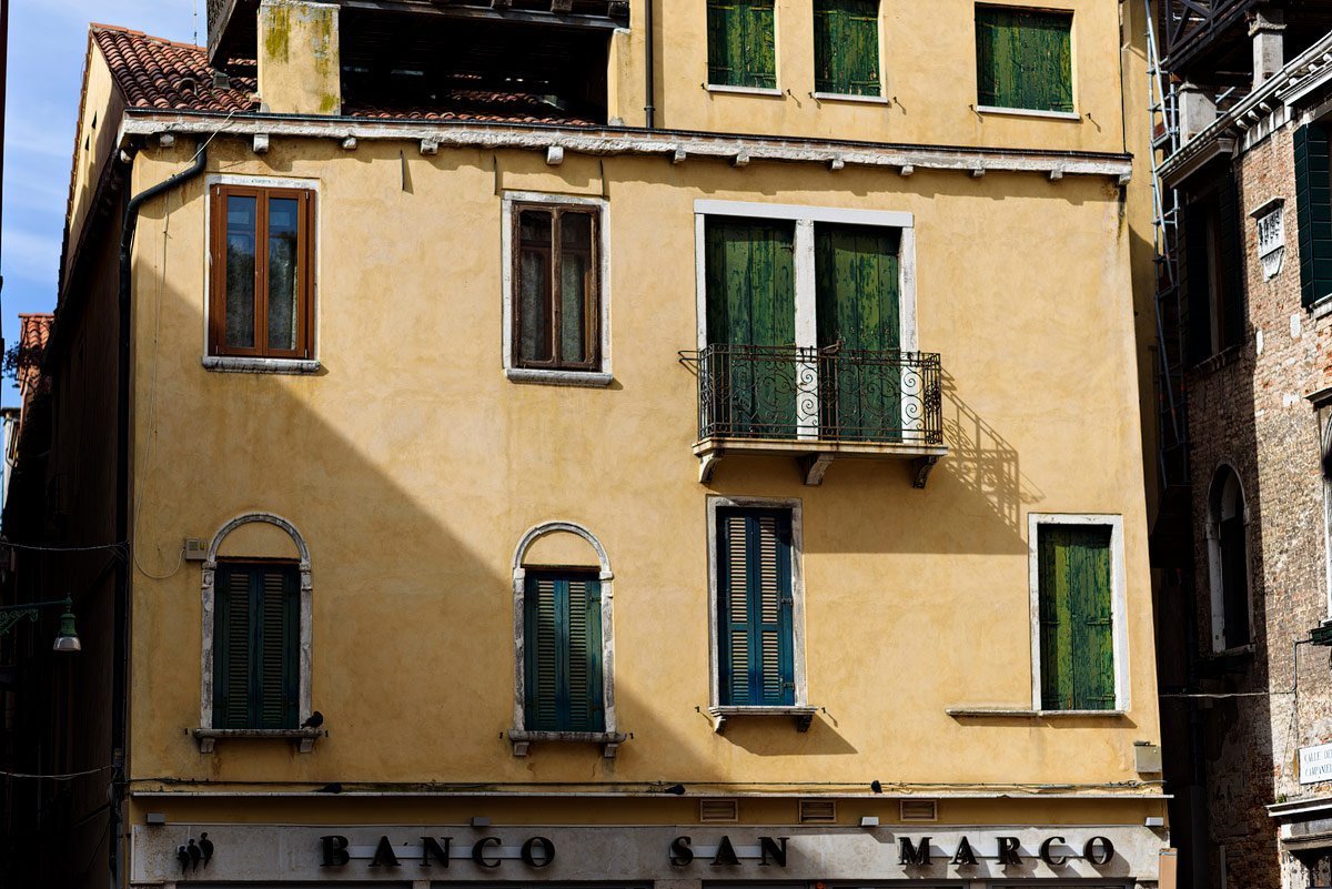 yellow building with green shutters in venice italy dallas travel photographer