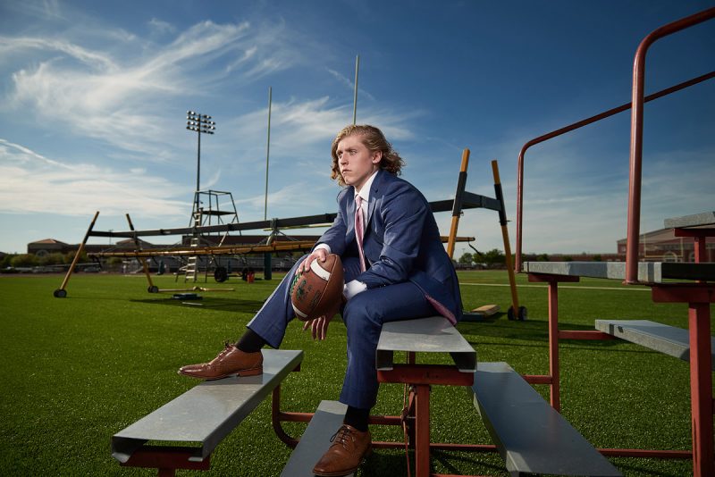 Prosper senior pictures of football player in suit at the practice field