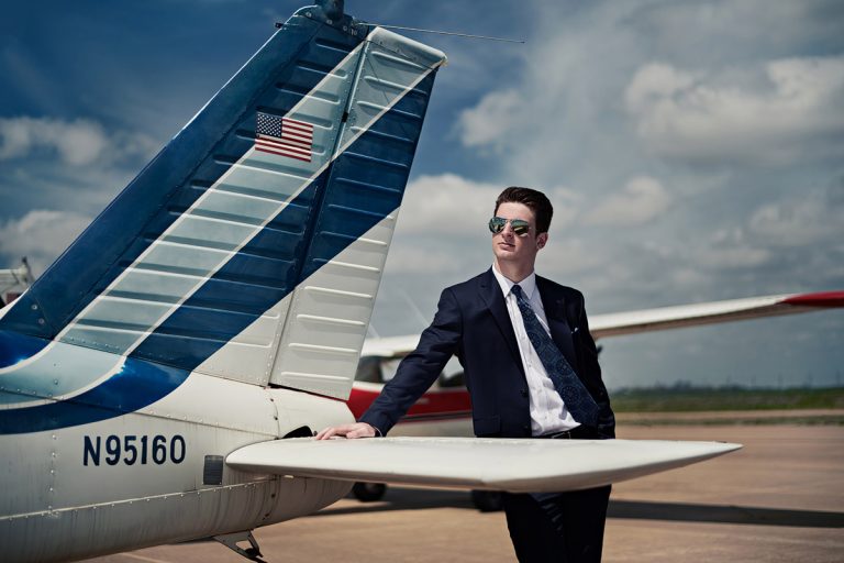 prosper senior photographer photographs student by plane with sunglasses